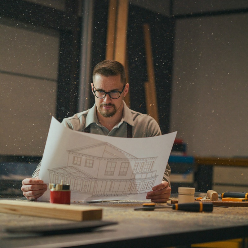 Matt Smith reviewing house plans at a workshop bench